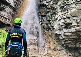 Un agente de la Guardia Civil de montaña observa el descenso de un compañero en el lugar del siniestro.