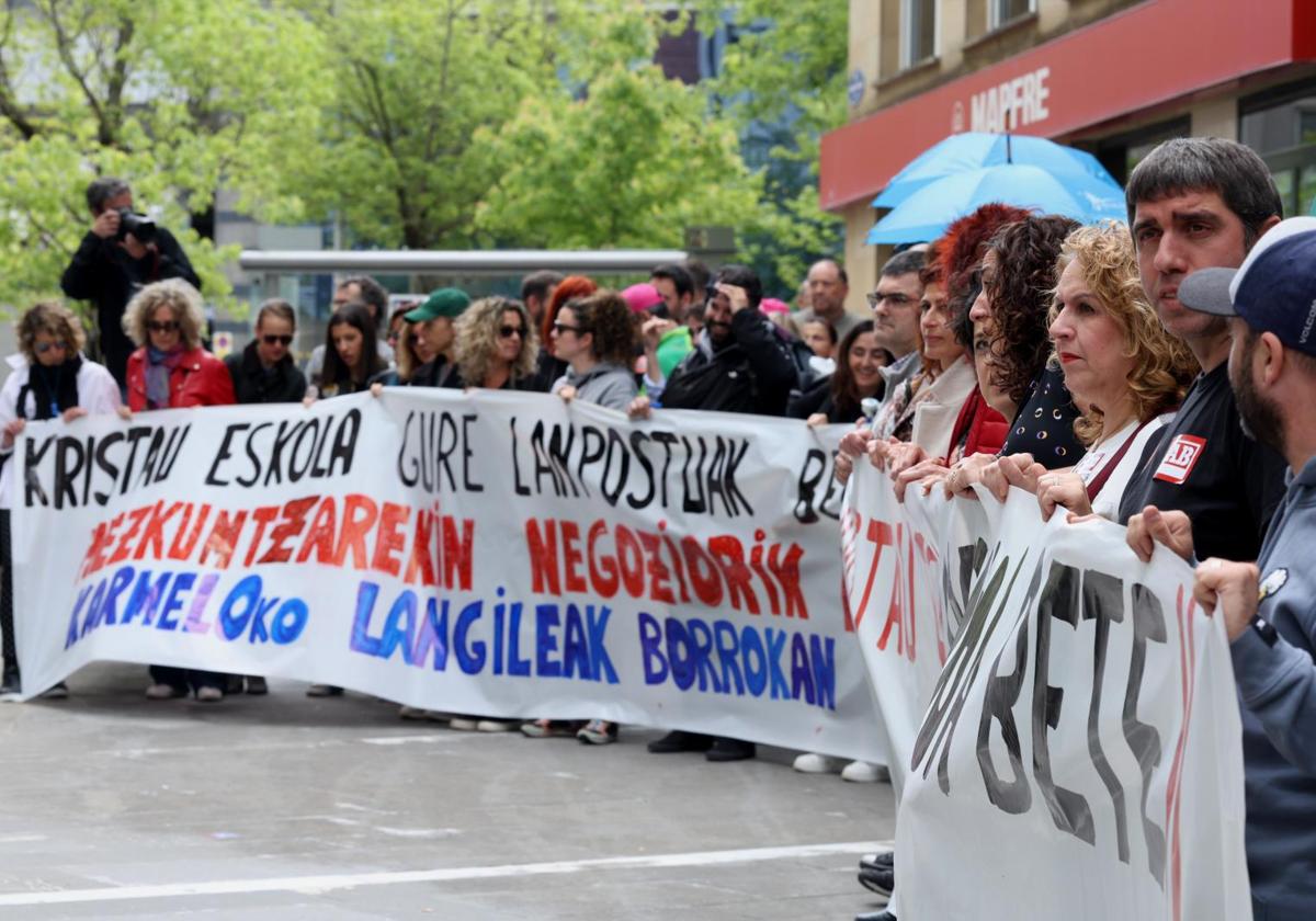 Delegados sindicales se concentran ante la sede de Kristau Eskola en Donostia.