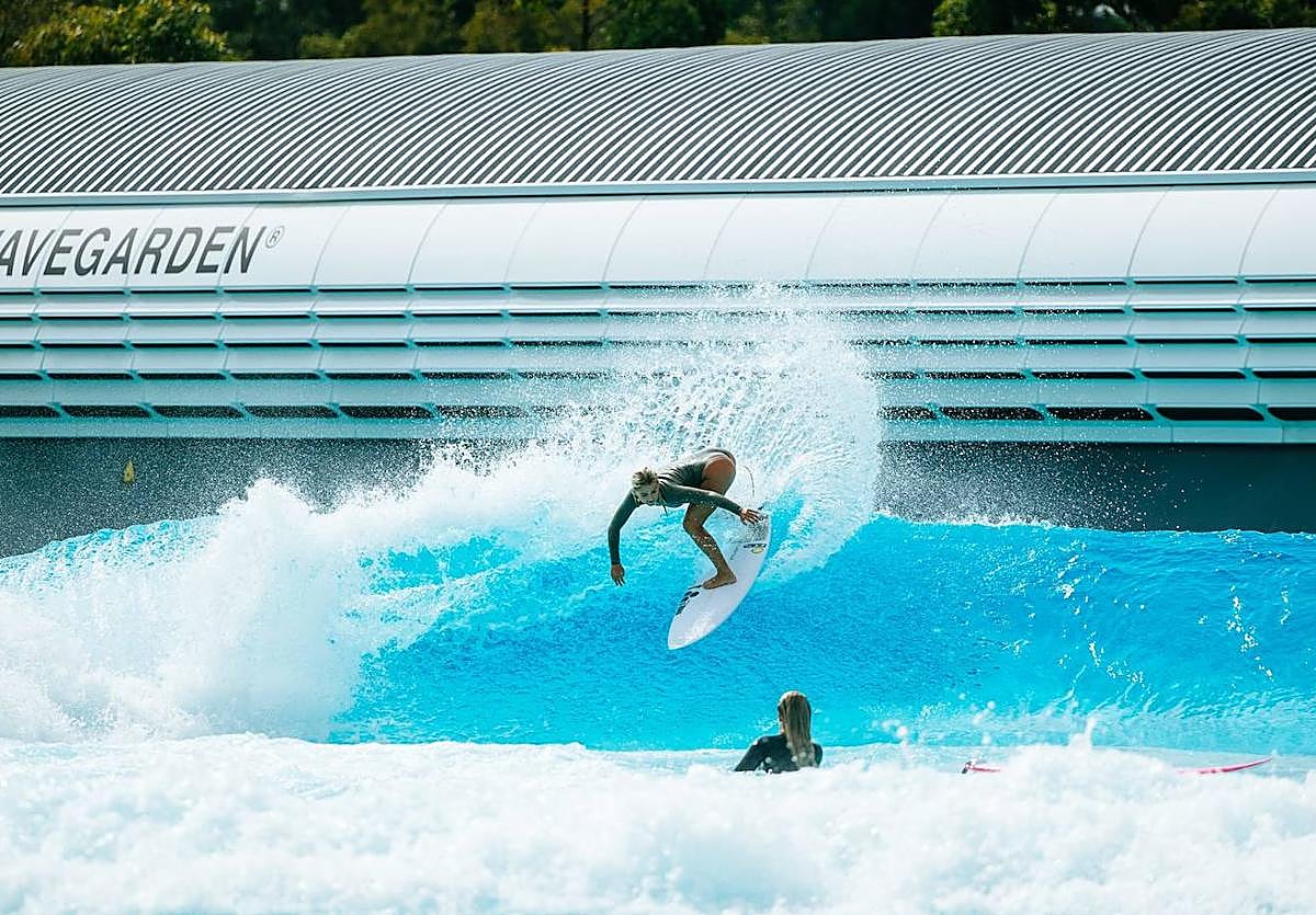 Una surfista toma una ola.