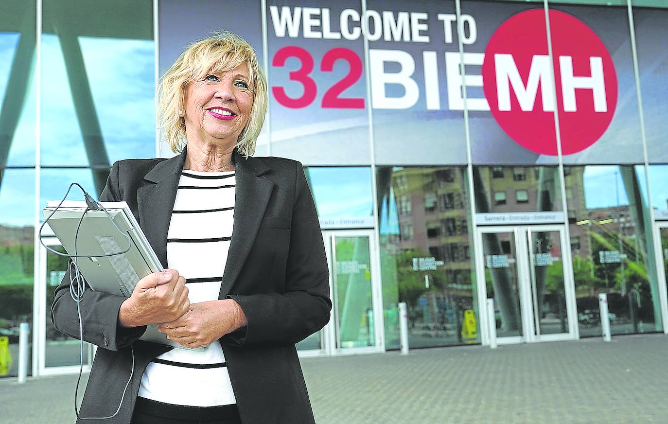 La directora de la Bienal frente a los carteles del evento que ya se han montado en el BEC.