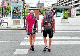 Dos peregrinos caminan por el centro de la ciudad.