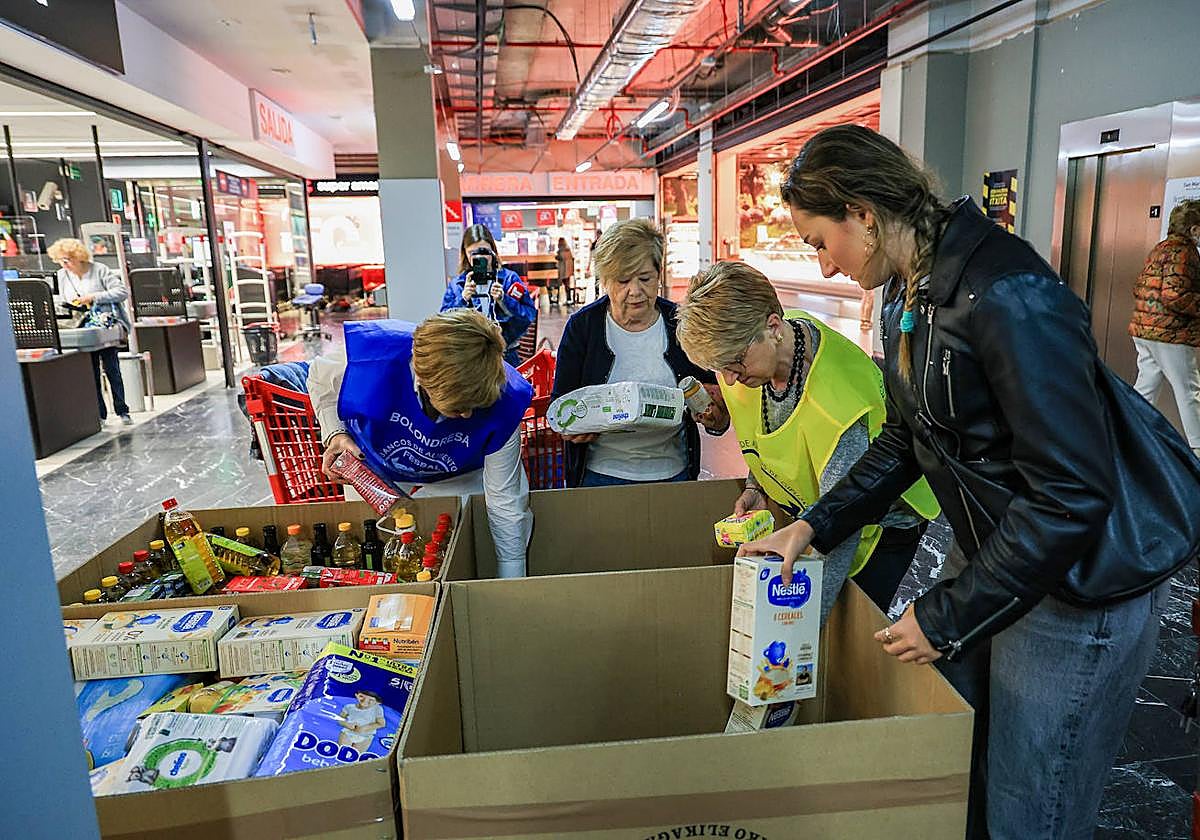 Varias voluntarias llenan cajas con la comida donada por los ciudadanos en un supermercado del centro de Donostia.
