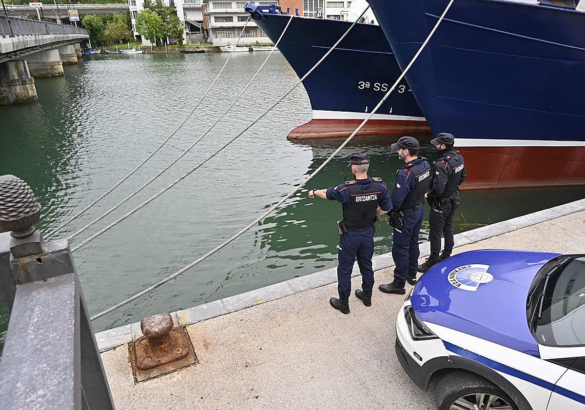 Imagen principal - Imagen del rescate y tres tres agentes ante el lugar donde cayó el joven