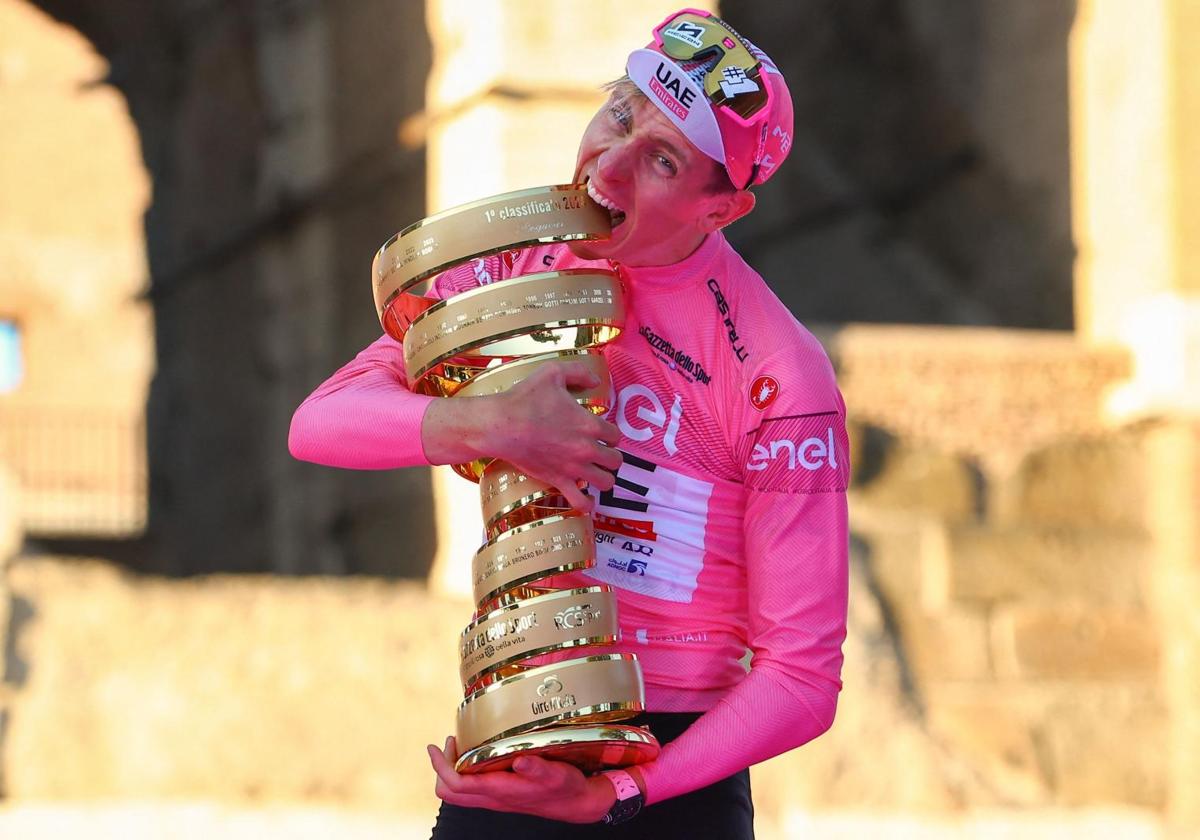 Tadej Pogacar muerde el trofeo 'Senza Fine' en el podio de Roma, ante el Coliseo