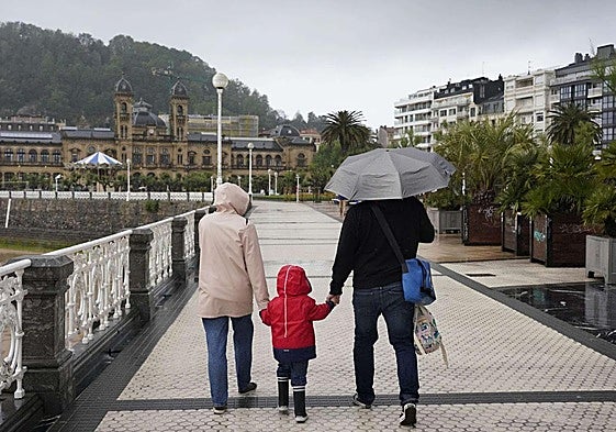 Una familia camina bajo la lluvia en San Sebastián.