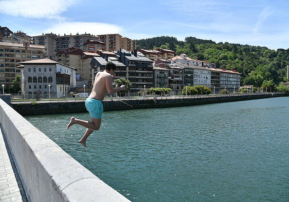 Chapuzón. Un joven se lanza al agua en Deba para refrescarse del calor.