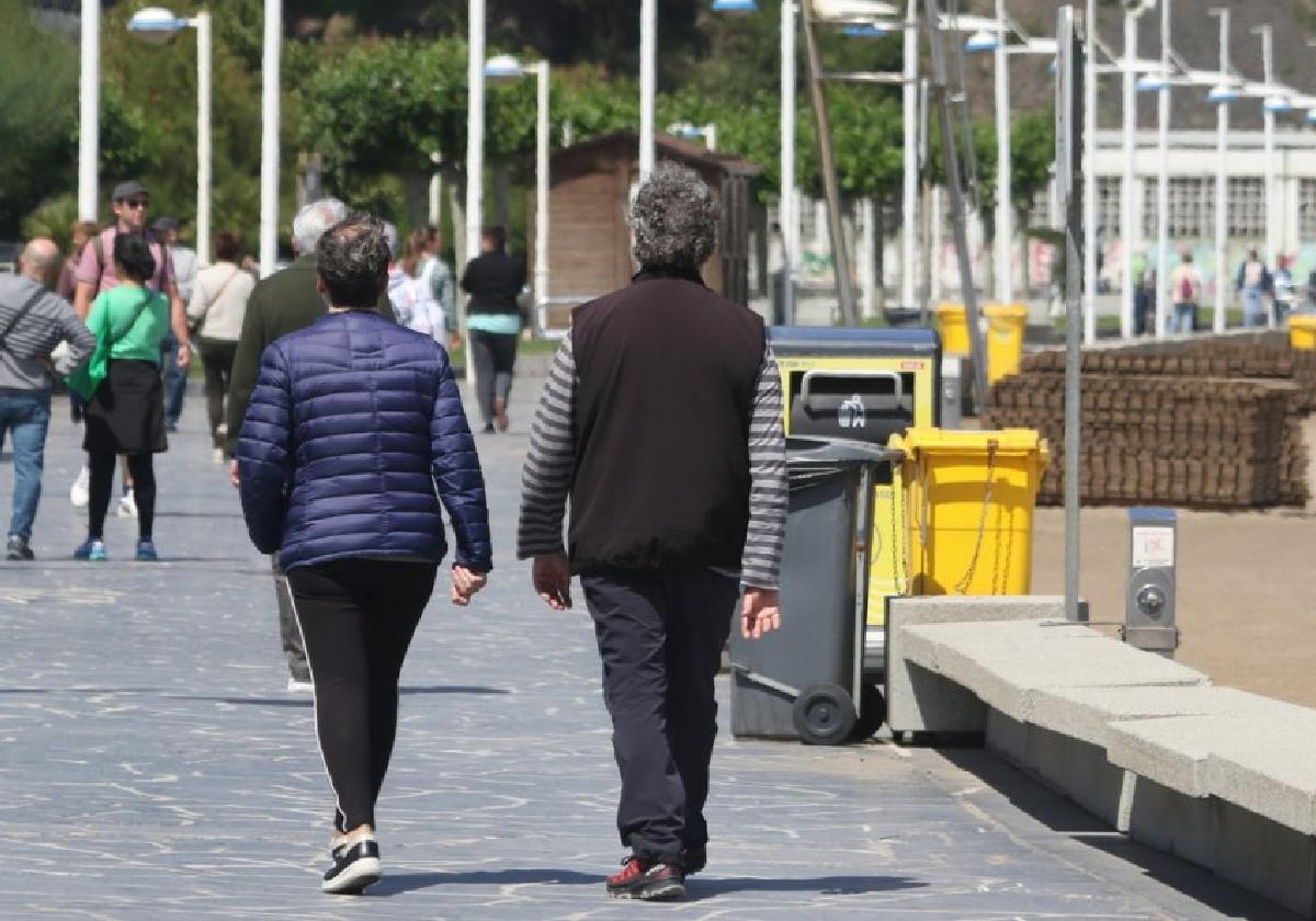 Personas mayores caminan por el paseo de Deba, días antes del inicio de la temporada de playas.