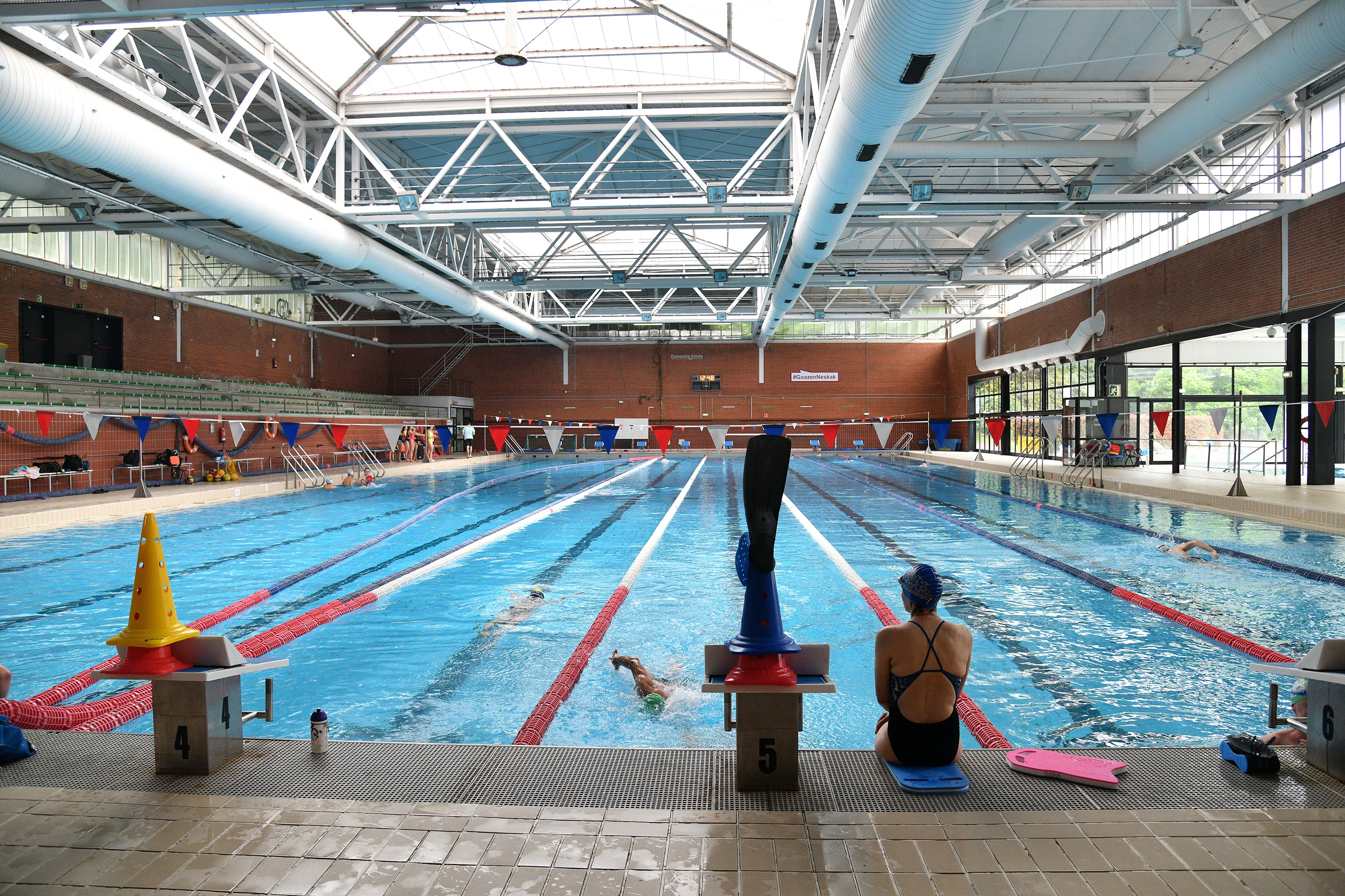 Una nadadora descansa en el bordillo de la pileta tras su sesión de entrenamiento