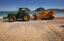 Excavadora trabajando en la retirada de piedras en la playa de Ondarreta.