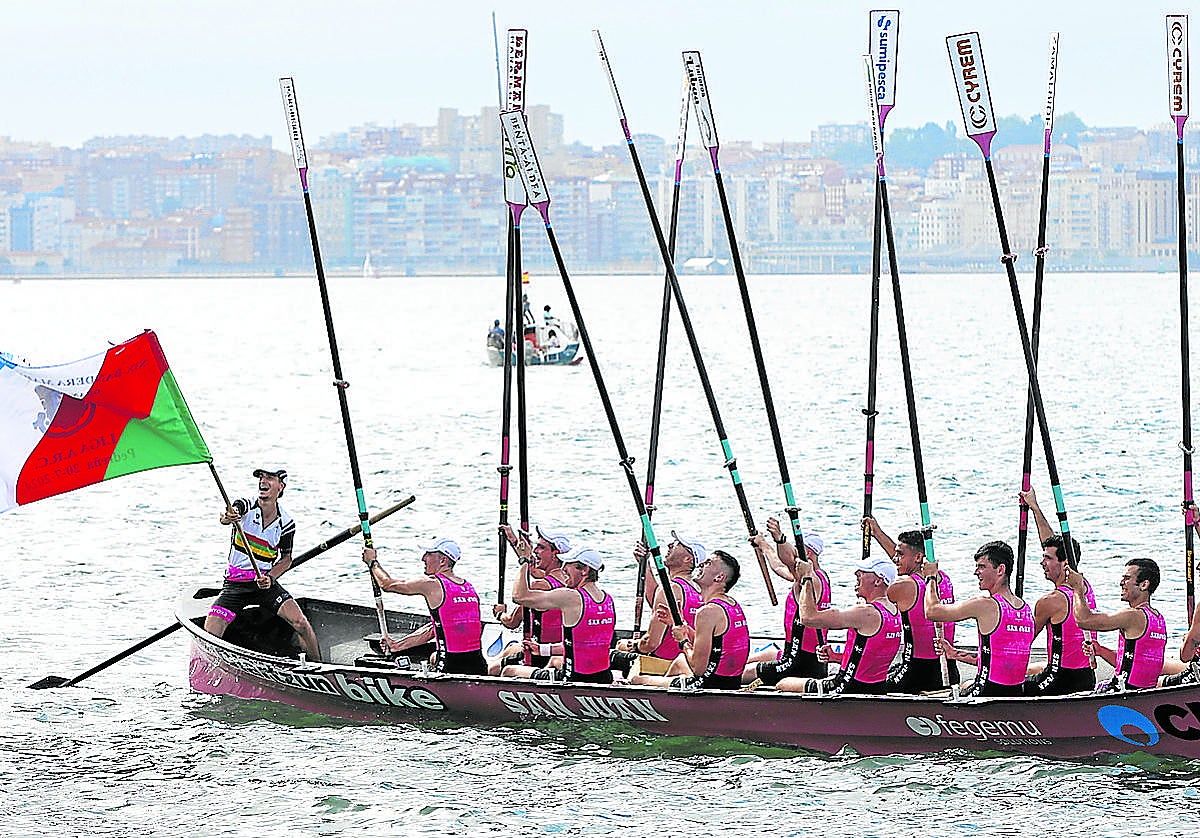 Ander Egaña, patrón de San Juan, ondea la bandera con su tripulación alzando los remos.