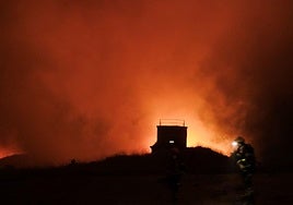Un bombero vigila las llamas que se extienden en el interior del fuerte de San Cristóbal a las tres de la madrugada