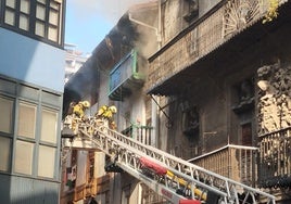 Los bomberos, con la escala en dirección al piso más afectado por las llamas.