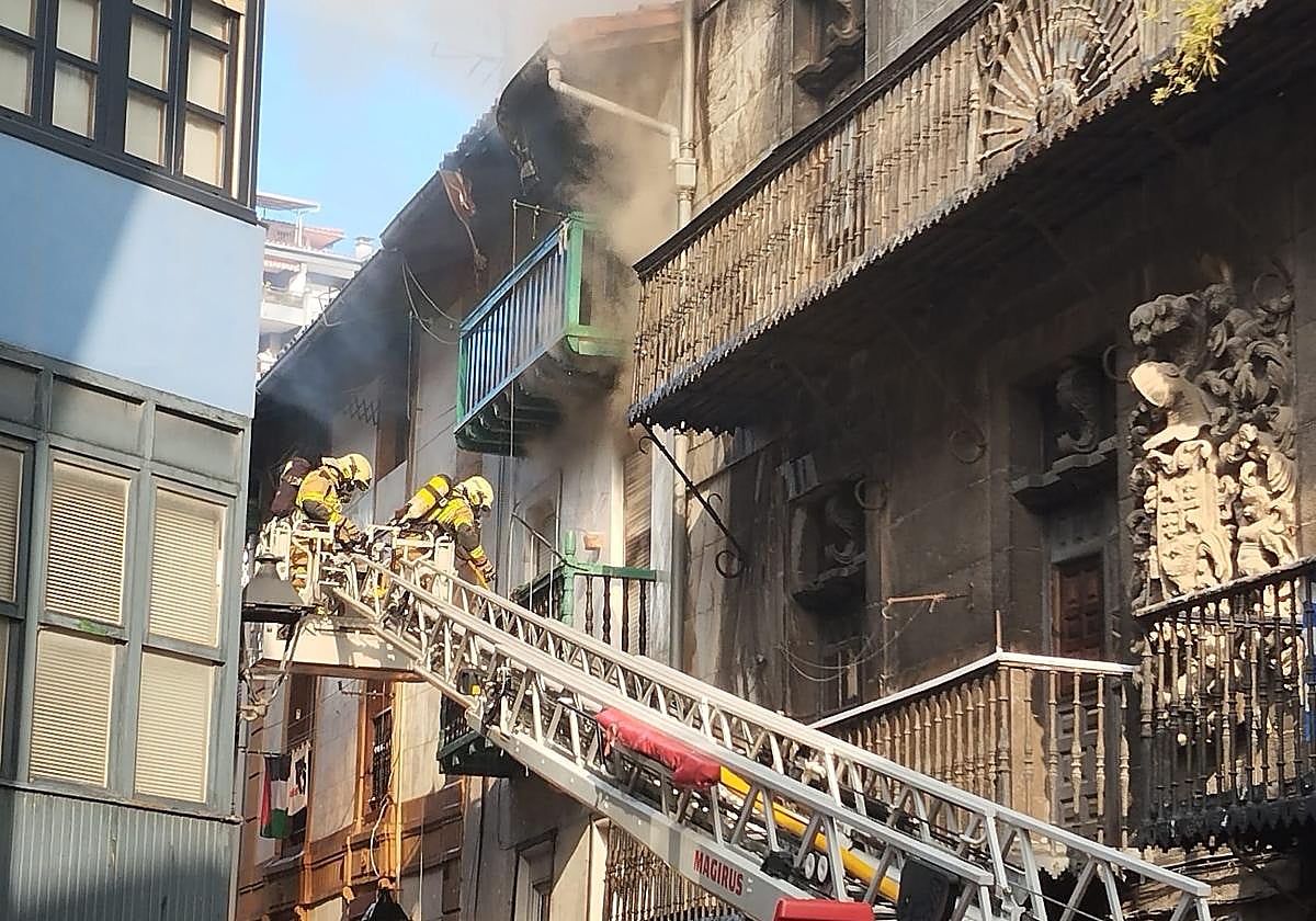 Los bomberos, con la escala en dirección al piso más afectado por las llamas.