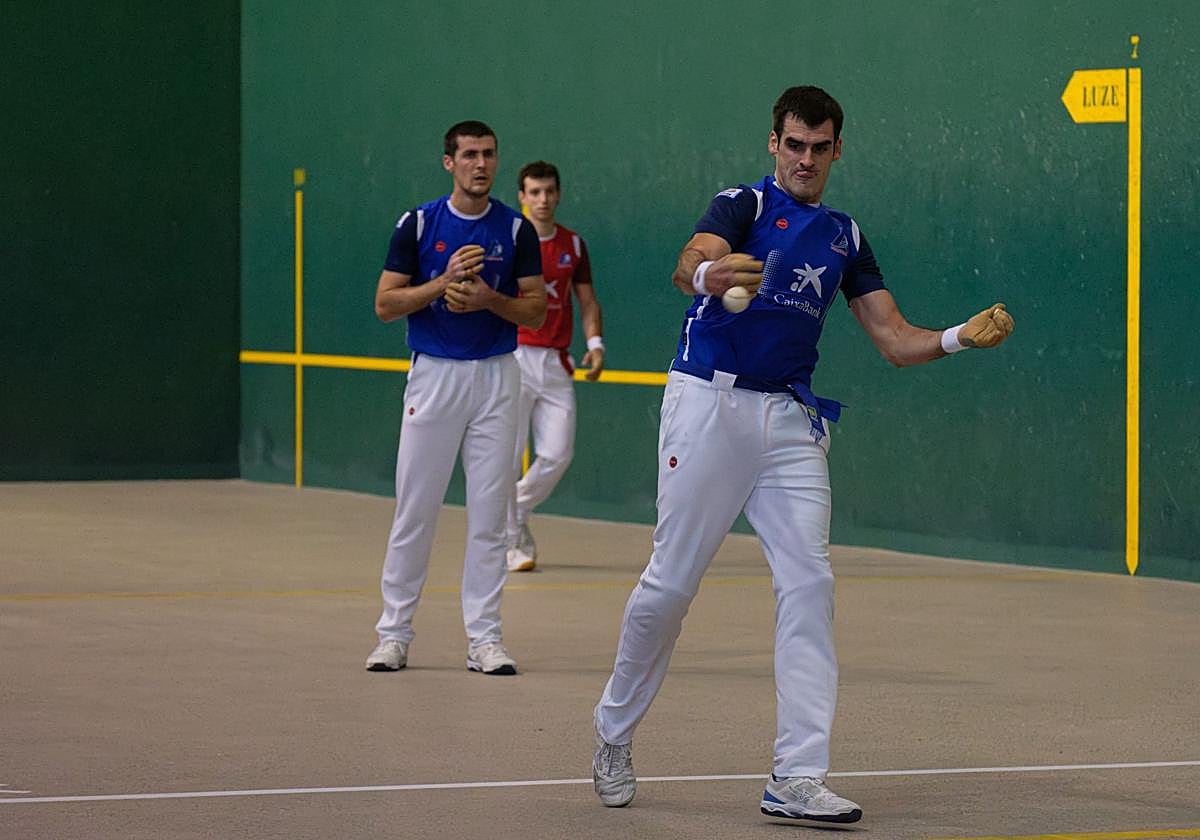 Ezkurdia golpea la pelota, con Rezusta y Martija al fondo.