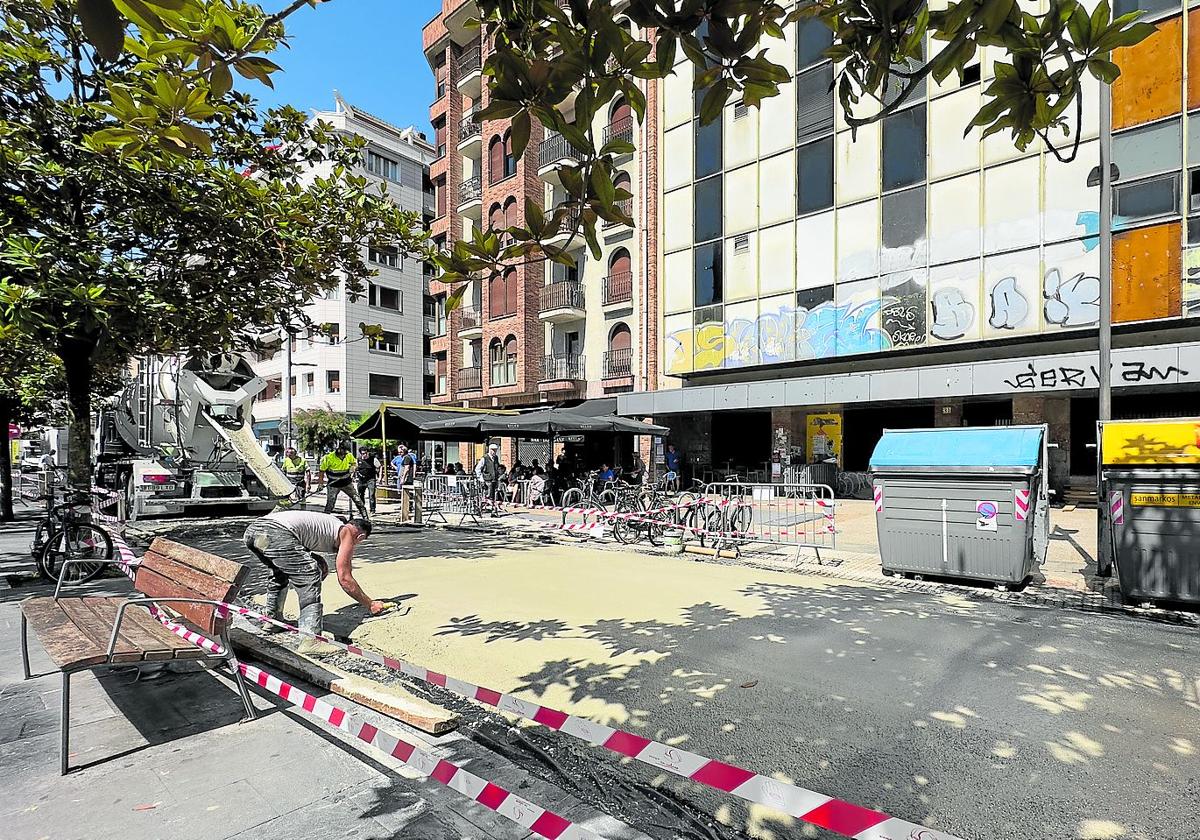 Operarios hormigonan el pavimento de la plaza de Cataluña para la entrada y salida de los camiones a la obra en el viejo edificio de Telefónica.