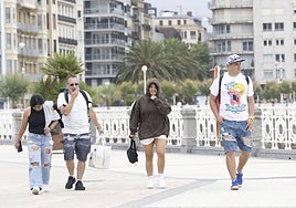 Varias personas pasean con ropa de entretiempo por Donostia pese a ser mediados de julio.