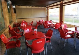 Imagen de archivo de la terraza de un bar con sillas y mesas Mahou.