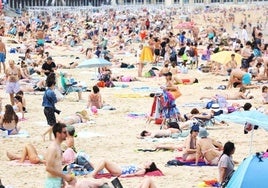 Decenas de personas disfrutan de un día de playa este verano en San Sebastián.