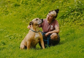 María, de la protectora, junto a 'Lou', uno de los cien perros que esperan ser adoptados.