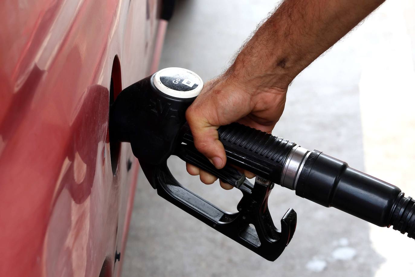 Un hombre reposta en una gasolinera.