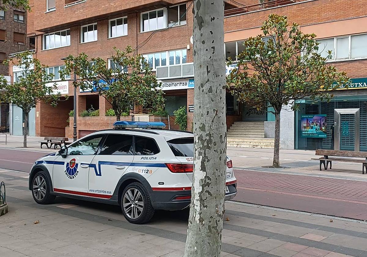 Un coche de la Ertzaintza frente a la sucursal bancaria donde se produjo el robo.