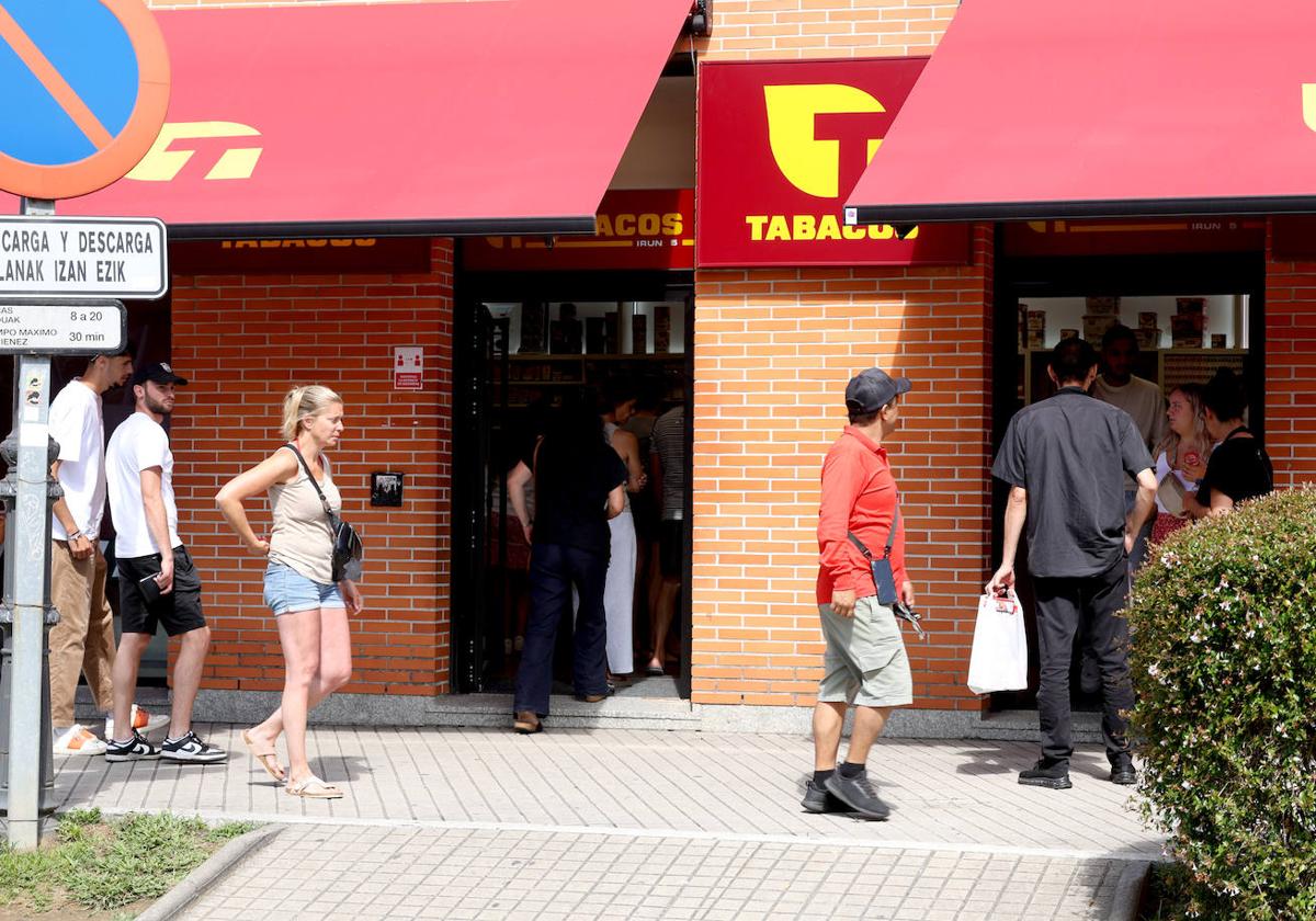 Varios clientes abandonan uno de los estancos de Behobia con bolsas llenas de cartones de tabaco mientras que otros acceden al local.