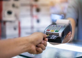 Un usuario paga en un comercio con su tarjeta de crédito.