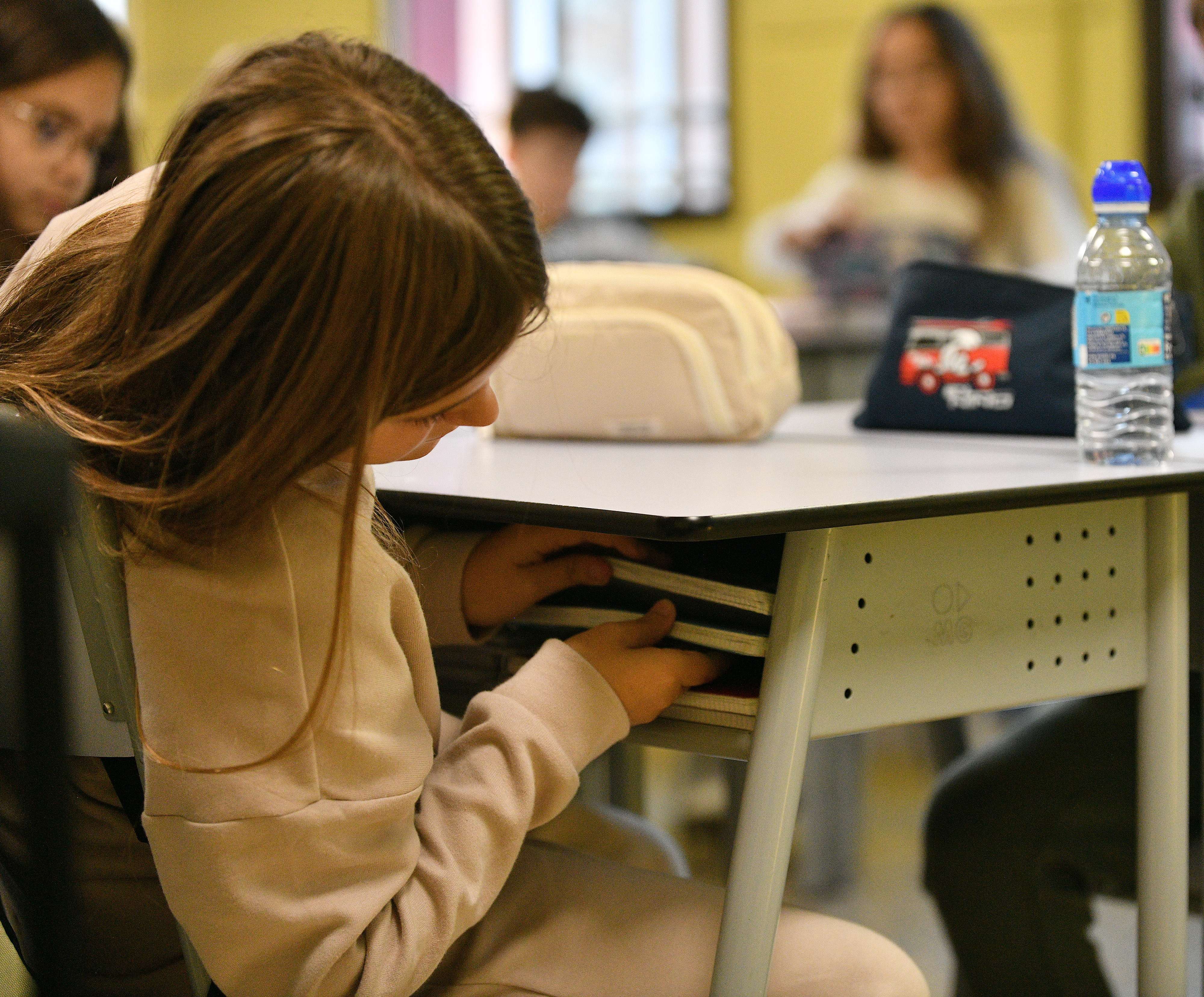 Una alumna revisa sus libros de texto.