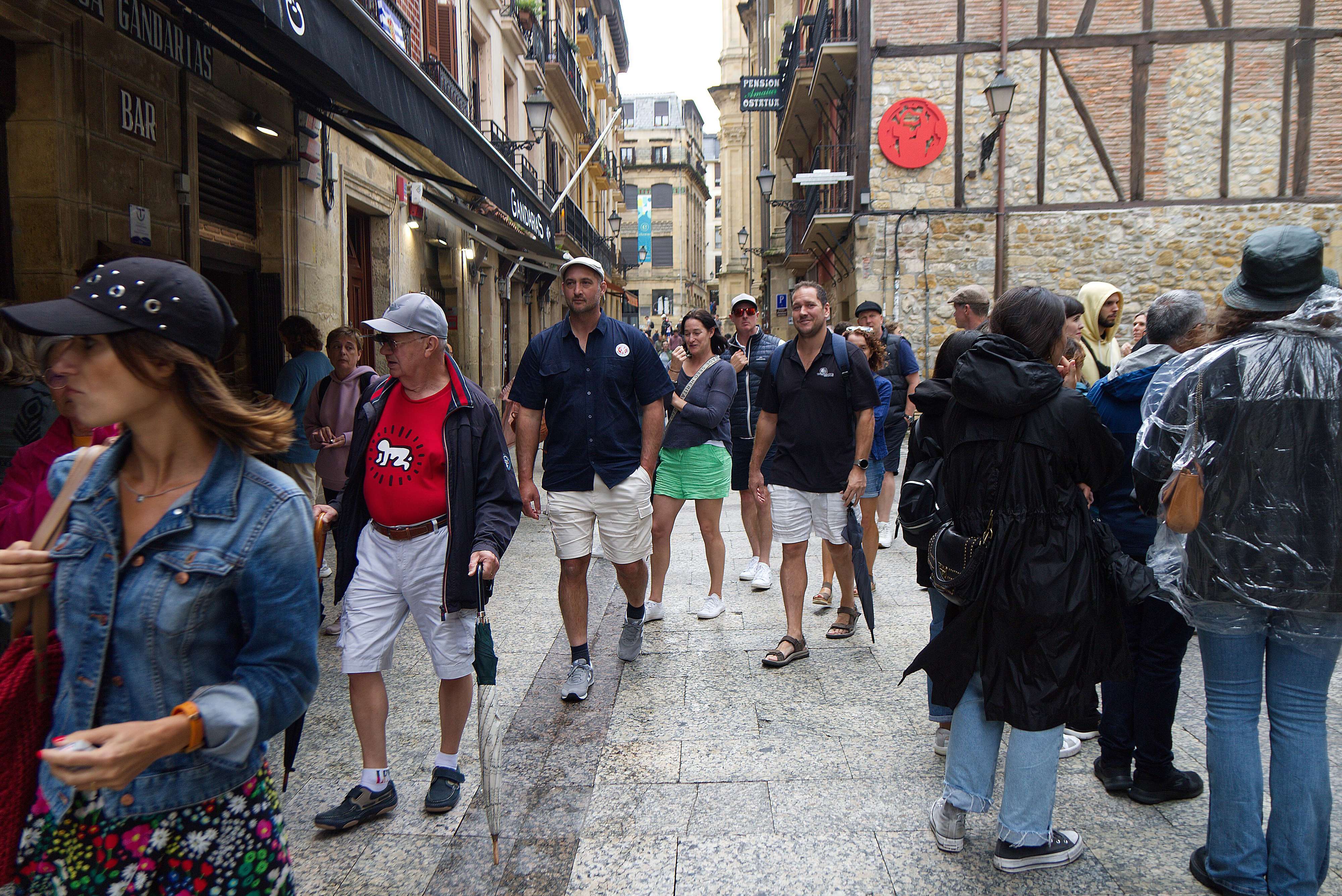 Una familia de turistas camina por una calle de la Parte Vieja de San Sebastián.