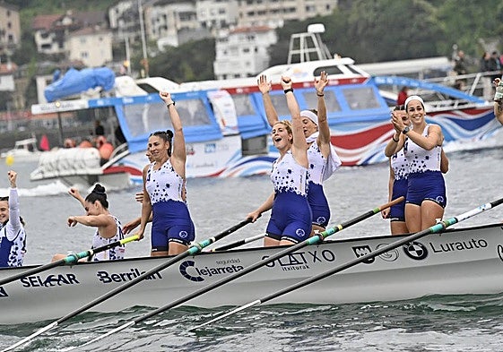 Las remeras de Arraun Lagunak ondean la Bandera de La Concha a su llegada a la rampa del muelle.