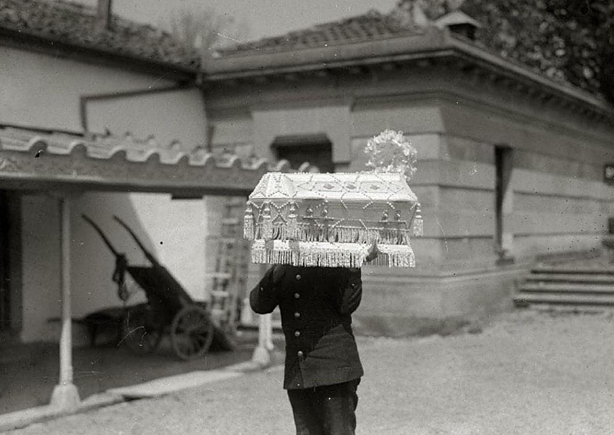 Imagen secundaria 1 - Traslado de un féretro de una vivienda de Donostia al cementerio de Polloe. Un operario lleva a hombros el ataúd de un niño, y comitiva fúnebre en Arrasate.
