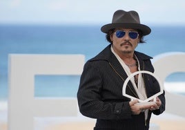 Johnny Depp posa con el logo del Zinemaldia durante el photocall de su película.