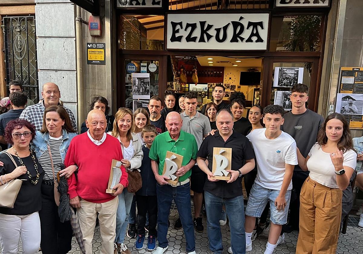 Tres generaciones de la familia Balda, propietarios del bar Ezkurra, acompañados de trabajadores en el día del cierre del histórico establecimiento de Gros.