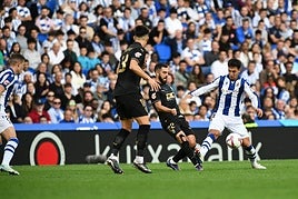 Kubo, arriba, juega el balón ante Correia y Zubimendi lo protege abajo del acoso de Rioja el sábado en Anoeta.