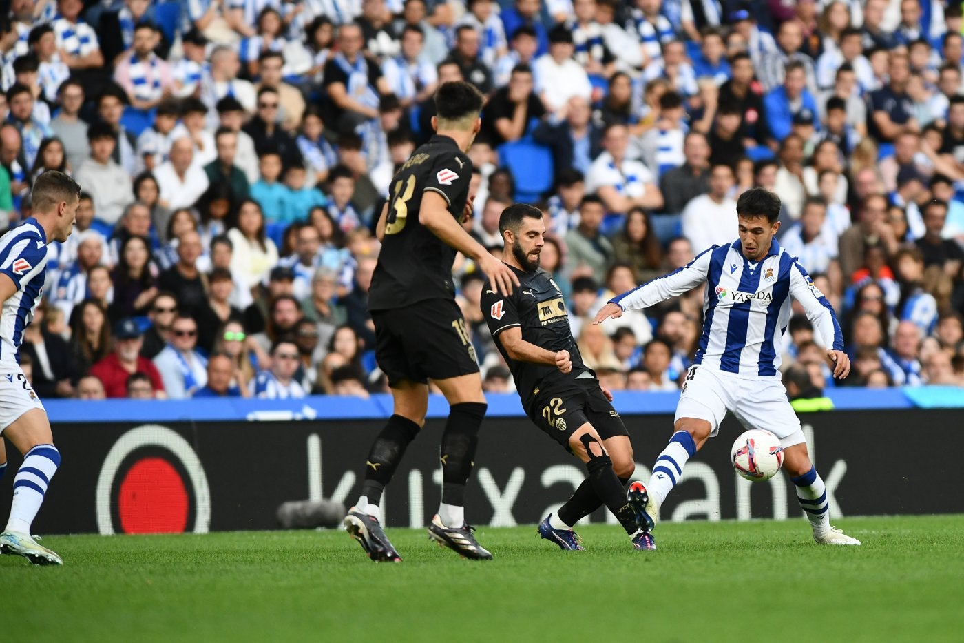 Kubo, arriba, juega el balón ante Correia y Zubimendi lo protege abajo del acoso de Rioja el sábado en Anoeta.