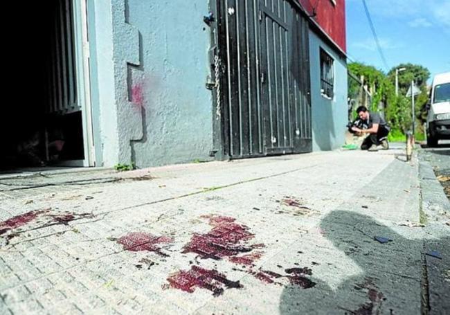 Restos de sangre en la acera donde se produjo el tiroteo.