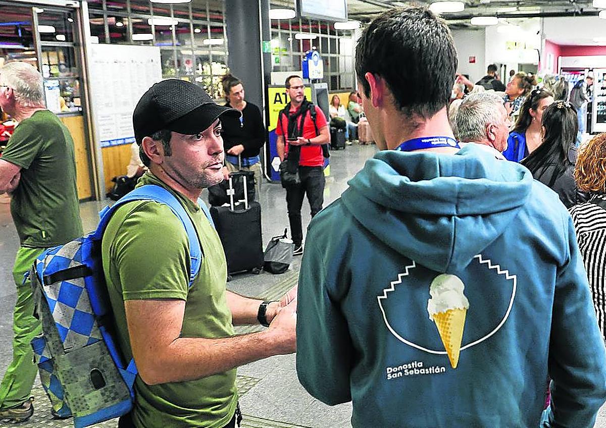 Imagen secundaria 1 - Las dos guías Ana y Cristina, el técnico de Donostia Turismoa junto al responsable de un grupo y una imagen del 'Decálogo del Buen Guía' que explica la normativa.