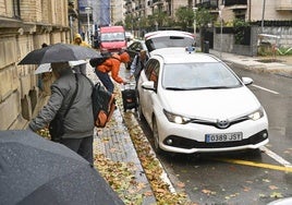 Personas esperando un taxi en un día de lluvia en Donostia.