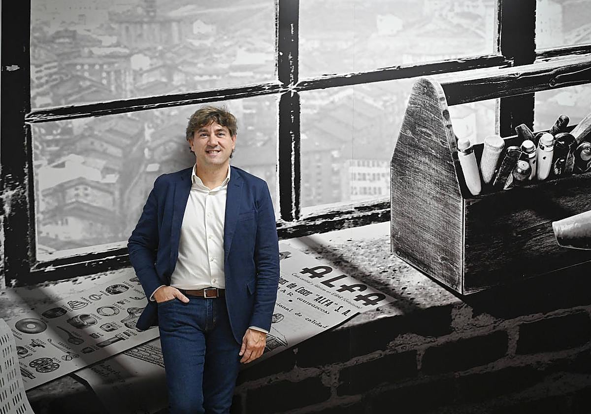 Eneko Andueza, secretario general del Partido Socialista en Euskadi, posa en la Casa del Pueblo de Eibar junto a una imagen de la histórica empresa Alfa.