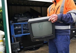 Un operario traslada un monitor en el Garbigune de Zumaia.