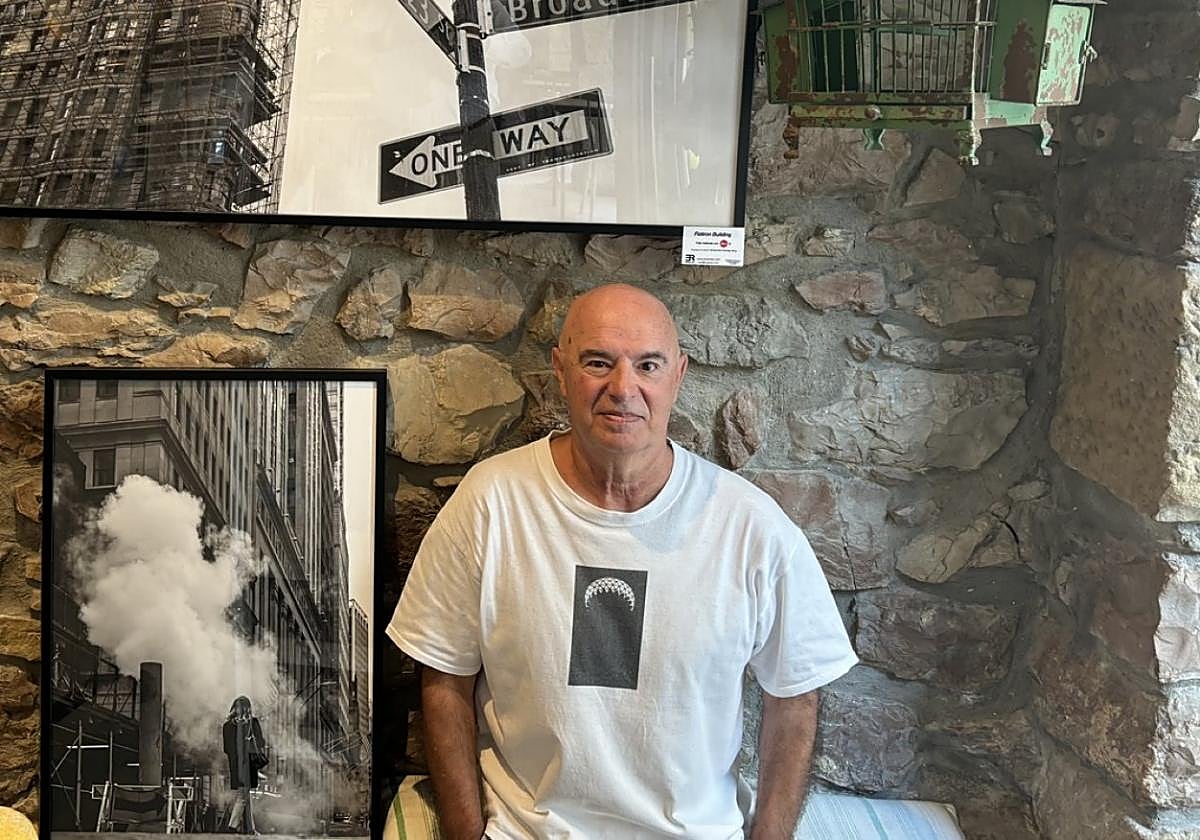 El fotógrafo Enrique Riu posa en el bar-restaurante La Taberna de Blas junto a un par de fotografías de la ciudad de Nueva York.