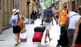 Turistas arrastran unas maletas en la Parte Vieja donostiarra.