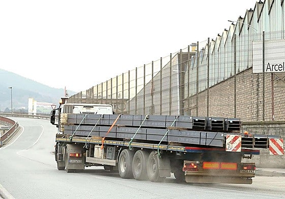 Un camión con vigas circula junto a la planta de ArcelorMittal en Olaberria.