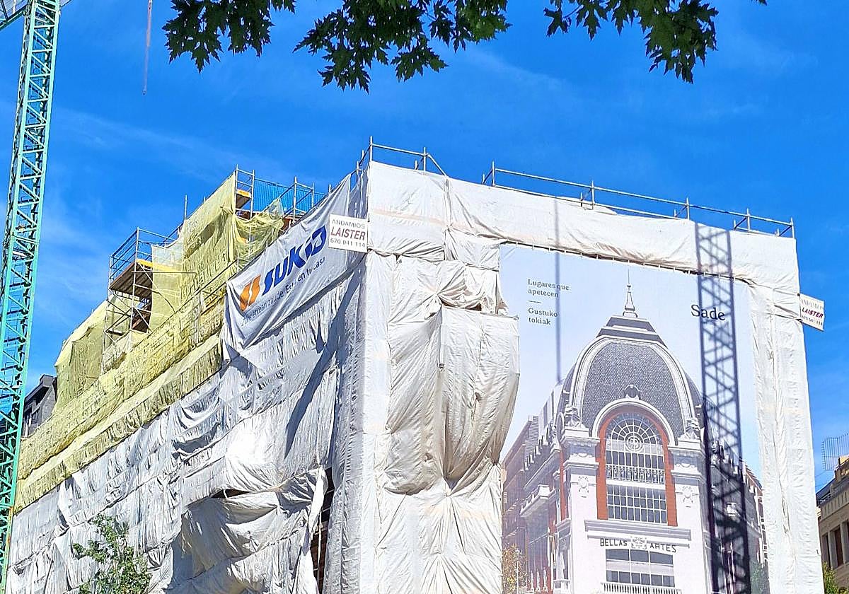 El exterior del edificio envuelto con una lona opaca.