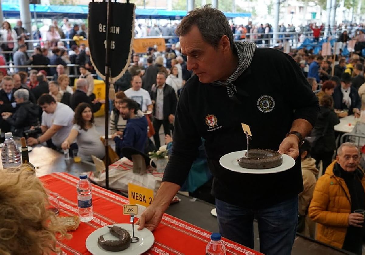 Martin Urkiola, presidente de la Cofradía de la Morcilla, acerca una morcilla a los catadores.