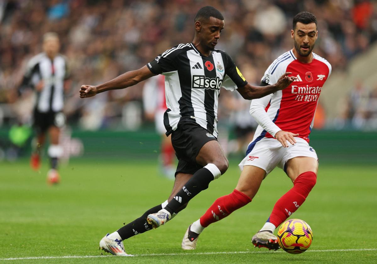 Alexander Isak conduce el balón ante la presión de Mikel Merino.