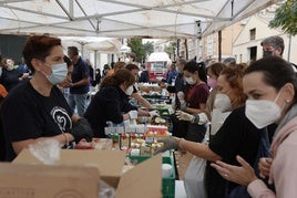 Vecinos de Paiporta se acercan a un punto de reparto de alimentos básicos,