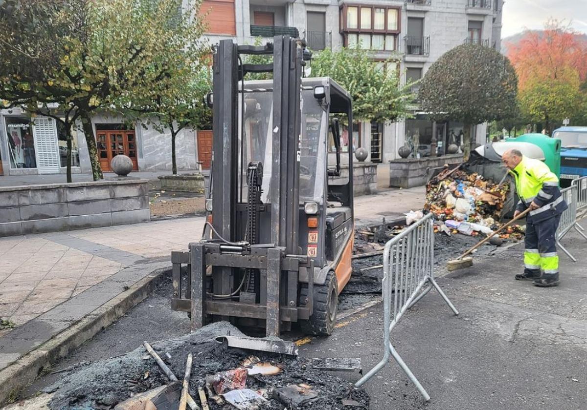 Un operario limpia en la zona en la que han quedado calcinados cuatro contenedores esta pasada madrugada.