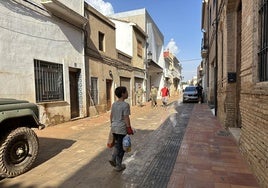 Ayuda. Hugo camina por las calles de Llocnou de la Corona afectadas por la DANA ofreciendo pan.