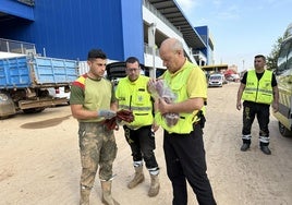 Iñaki y Eukeni, de DYA Gipuzkoa, entregan unos guantes a unos voluntarios de Granada.